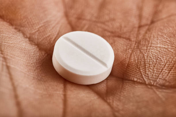 istock White round medical pill in the palm 1227367205