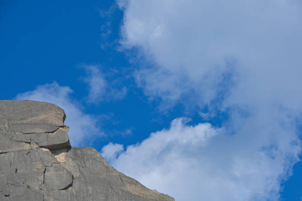 peak under blue sky with clouds, preparation for climbing rock ridge, journey in mountain valley
