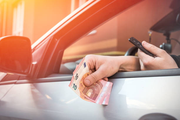 istock man counts euros while in a car to pay for parking or goods 1227367523