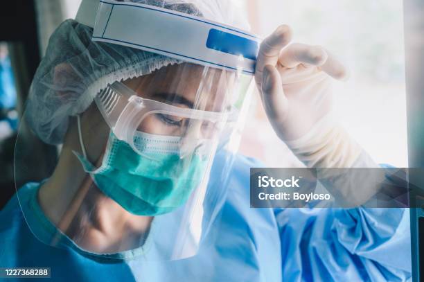 Nurse Having Headache And Tired From Work While Wearing Ppe Suit For Protect Coronavirus Disease Stock Photo - Download Image Now