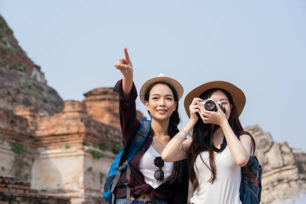 две азиатские женщины-путешественника с камерой и картой. - discovery forest lost confusion стоковые фото и изображения