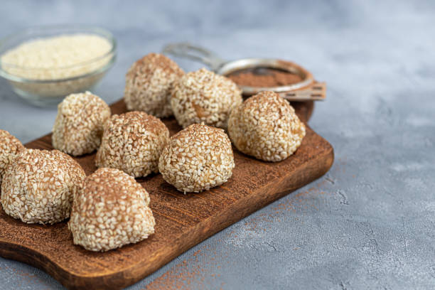 istock Energy bites without baking are made from ingredients - nuts, cocoa, chocolate, oats and sesame seeds. Located on a gray background. 1227371962