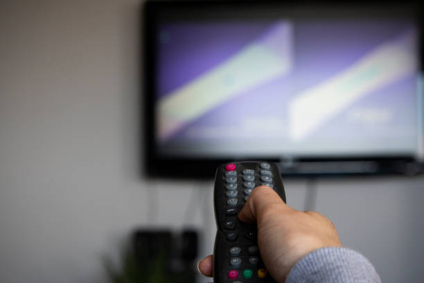 istock A woman watching and changing tv channel 1227372697