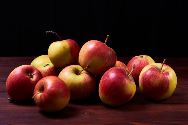 istock Fresh red-green apples on a wooden background. 1227373955