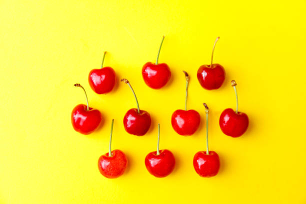 istock Fresh red cherries on yellow background, advertisement, poster 1227378395