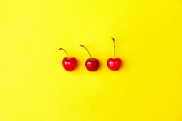 istock Fresh red cherries on yellow background, advertisement, poster 1227379046