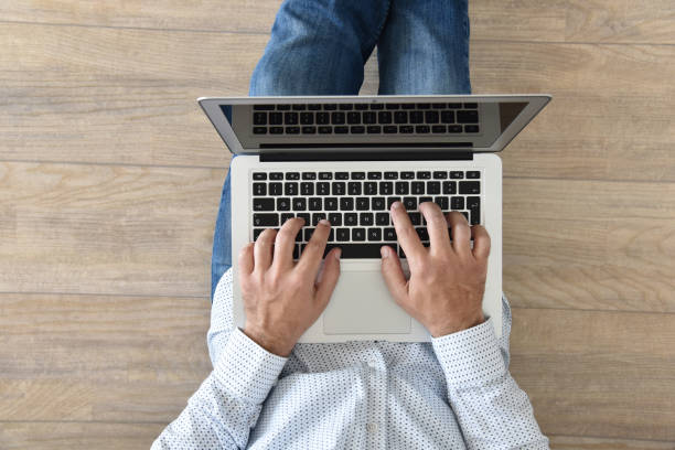 istock Work from home. A man holds a laptop on his lap. 1227380208