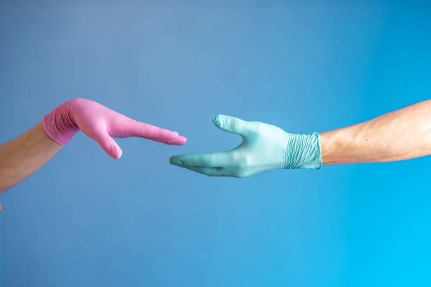 istock Two hands in rubber medical gloves. Relationships between people. Protection, isolation and distance during the pandemic 1227380922