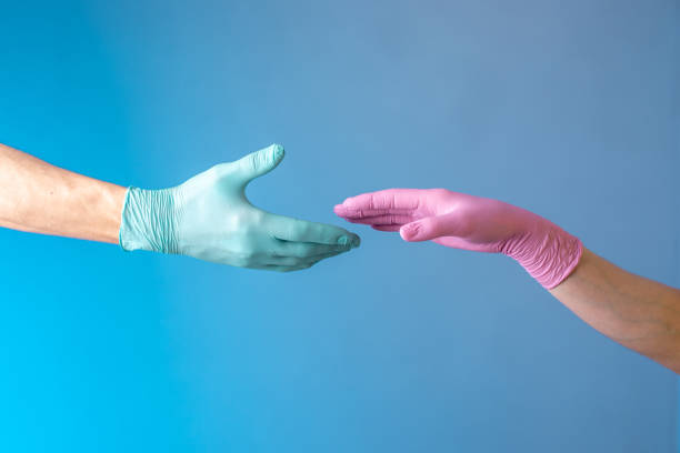 istock Two hands in rubber medical gloves. Relationships between people. Protection, isolation and distance during the pandemic 1227380931