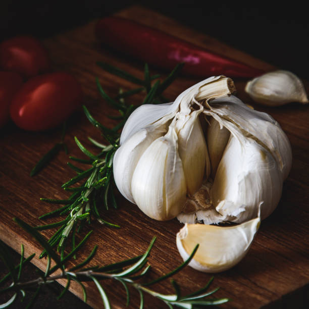 istock Garlic bulb with one separated clove on a dark brown background 1227385968