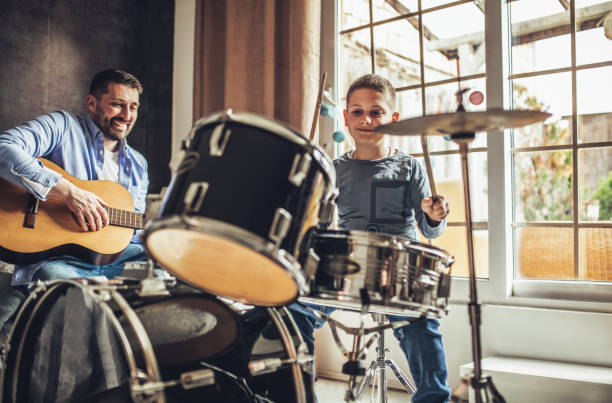 istock Father and son playing musical instruments at home 1227386024