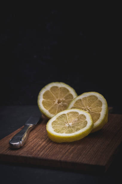istock Lemon cut into three pieces, lying with a knife on a wooden slat 1227386192