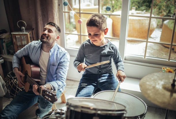 istock Father and son playing musical instruments at home 1227386530