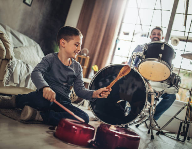 istock Father and son playing musical instruments at home 1227386535