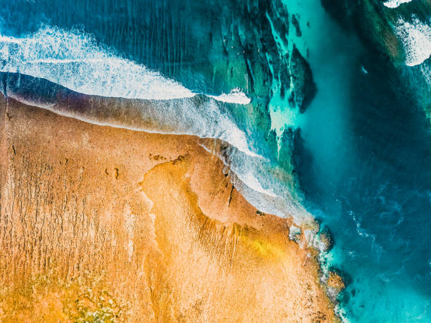 istock Drone Quadcopter With Digital Camera. Blue Ocean Water and Air bubbles Over White Background. Drone Pilotage at Sunset. Top Aerial View of Colourful Mountain Landscape with Isolated Beach. Bali 2020 1227387638