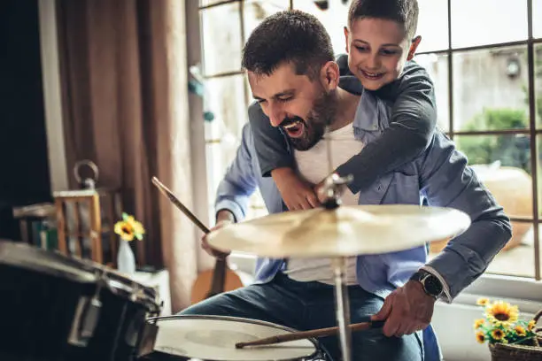 Father and son playing musical instruments at home