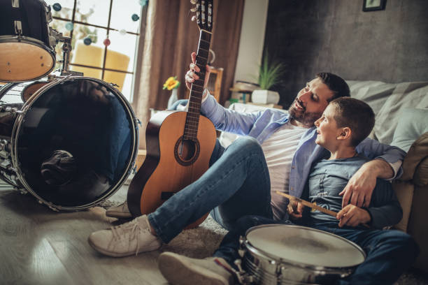istock Father and son playing musical instruments at home 1227388169