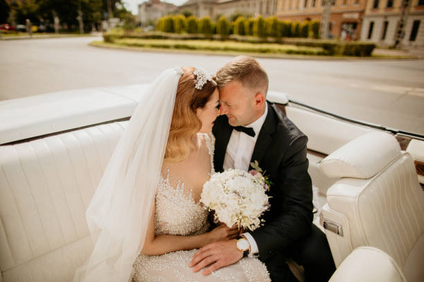 istock beautiful wedding couple posing in old retro car 1227388640