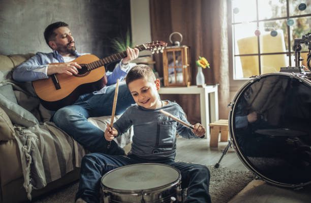 istock Father and son playing musical instruments at home 1227389140