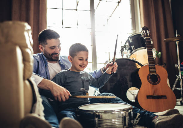 istock Father and son playing musical instruments at home 1227389412