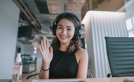 an asian chinese mid adult white collar worker talking to the camera video calling video conference with his business partners  with face mask