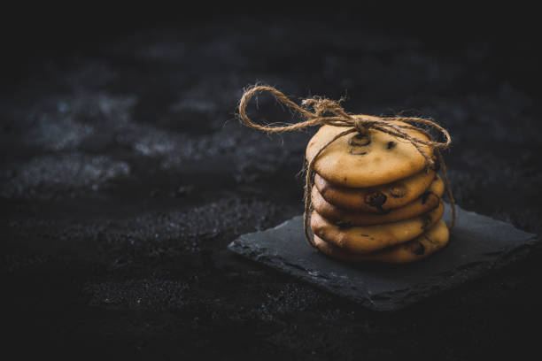 istock Homemade chocolate cookies on a slate plate on dark background 1227389821