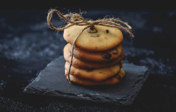 istock Homemade chocolate cookies on a slate plate on dark background 1227389940