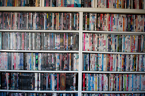 Movies in DVD cases on a shelf used as decoration for a pub