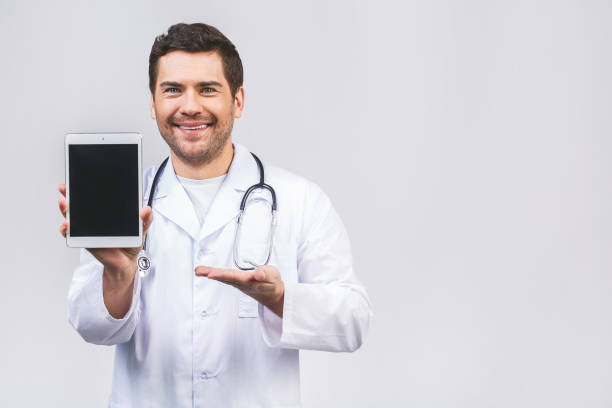 istock Portrait of friendly doctor presenting empty digital tablet screen. Isolated on white background. 1227392682