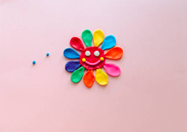 istock cute flower made of multi-colored plasticine clay on a pink background, multi-colored dough, minimal, children's crafts 1227392962