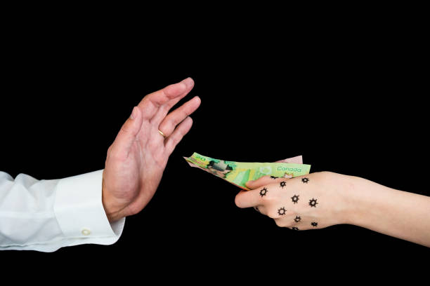 istock Man refusing Canadian cash from woman's hand contaminated with coronavirus COVID-19 1227396694