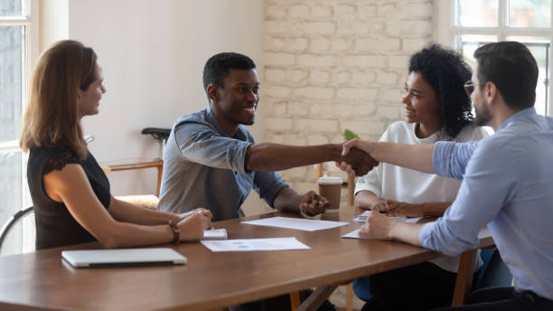 istock Happy diverse business partners shaking hands after successful negotiation 1227397603