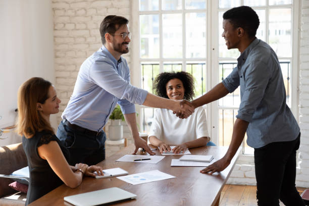 istock Happy diverse business partners shaking hands, making agreement 1227397608