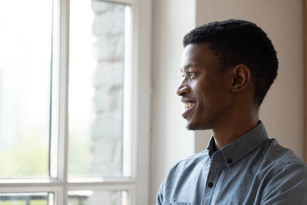 istock Smiling African American businessman looking at window and thinking 1227397622