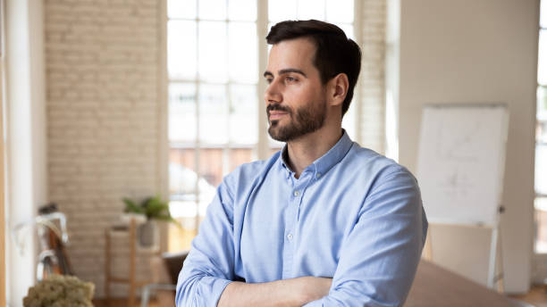 Thoughtful confident businessman looking in distance, pondering strategy