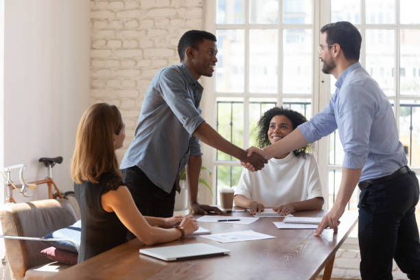 istock Smiling diverse business partners shaking hands after signing contract 1227397628