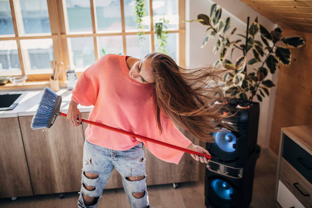 istock One happy young woman having fun while she cleaning the house 1227398887