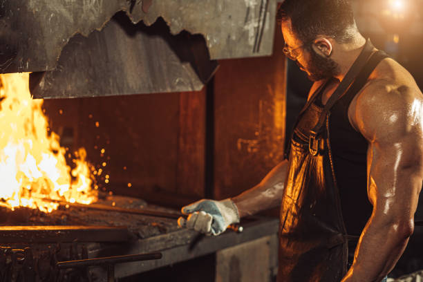 istock Caucasian young blacksmith, Iron Worker, artisan, master craftsman in workshop 1227399042