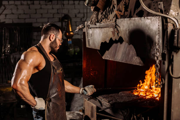 istock caucasian young metalworker working with heated metal in workshop 1227399185