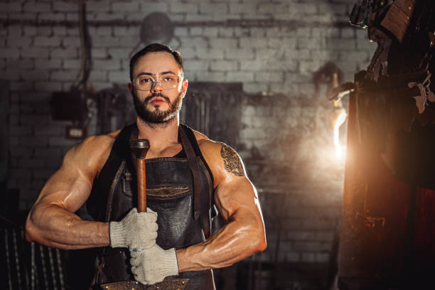 istock muscular forger male engaged in blacksmithing 1227399377