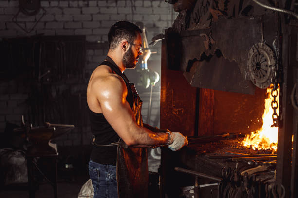 istock Caucasian young blacksmith, Iron Worker, artisan, master craftsman in workshop 1227400006