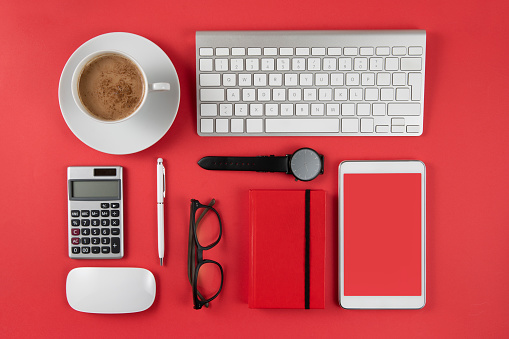 Directly above view of office equipments  and digital tablet with copy space on red background