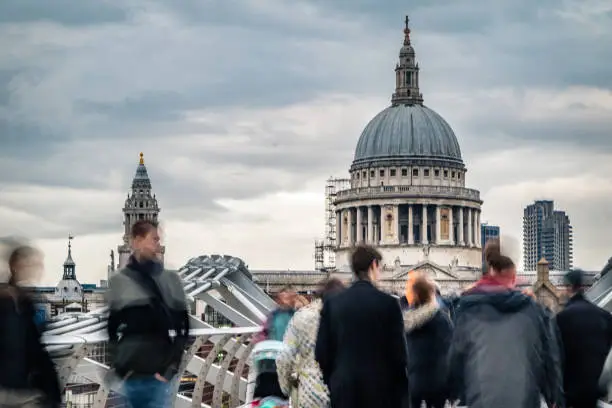 View from distance of Saint Paul's Cathedral in London city with motion blur commuters and tourists. Shot on Canon EOS R full frame system.