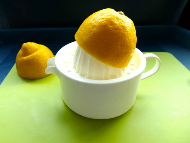 istock Halved lemon is juiced on a white lemon press. Cut out, close up 1227404175
