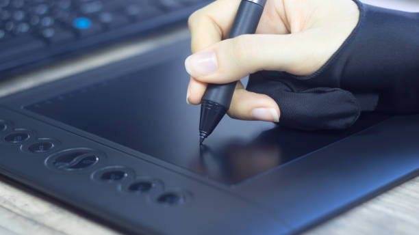 istock A woman's hand in a special glove draws on a graphic tablet. Freelance. Designer Illustrator draws comics, sketches. Digital tablet, visual, multimedia, pad, skill, touch, vision, digital art, image. 1227404751