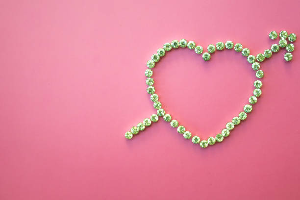 istock diamond heart with arrow, valentines day, pink background, flat lay 1227405873