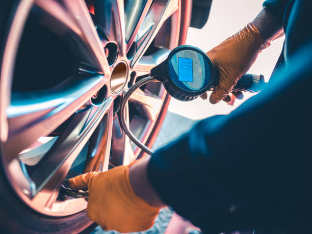 auto mechanic inflating tire - inflating imagens e fotografias de stock