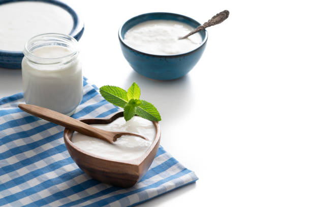 cuenco de madera casero en forma de corazón de yogur con hojas de menta y recipiente de vidrio aislado en blanco - spoon napkin silverware white fotografías e imágenes de stock