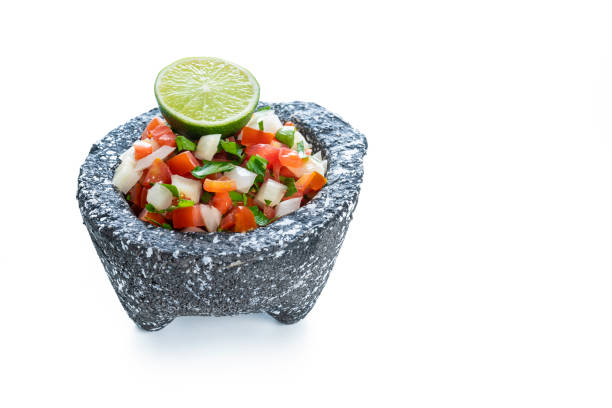 Pico de Gallo sauce Mexican recipe in stone molcajete isolated on white background