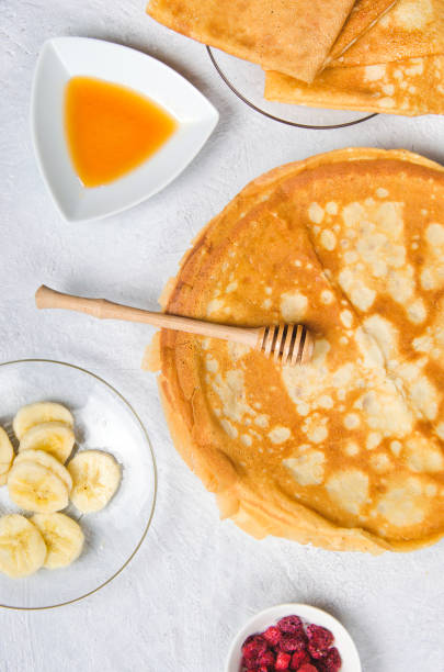 istock Pancakes with berries and honey for breakfast on white table 1227411721